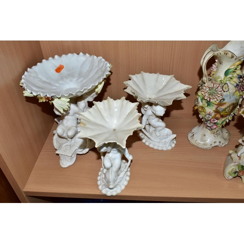 389 - SEVEN CERAMIC PIECES WITH MOULDED CHERUB DECORATION, comprising a centrepiece encrusted with flowers... 