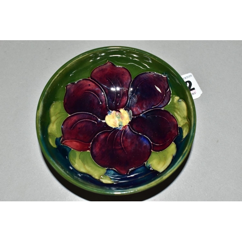 402 - A SMALL MOORCROFT POTTERY 'CLEMATIS' FOOTED DISH, diameter 11.5cm, a mauve clematis decoration on a ... 