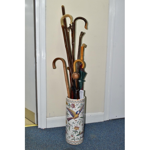 477 - A STICK STAND OF WALKING STICKS AND UMBRELLAS, to include a Knobkerrie length 77.5cm (splits to base... 