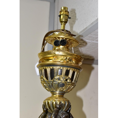 504 - A DECORATIVE ELECTRIC TABLE LAMP IN THE FORM OF AN OIL LAMP, comprising a cast brass base, reservoir... 