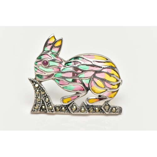 14 - A WHITE METAL PLIQUE A JOUR BROOCH, in the form of a rabbit, set with a red cabochon eye, decorated ... 