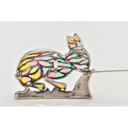 14 - A WHITE METAL PLIQUE A JOUR BROOCH, in the form of a rabbit, set with a red cabochon eye, decorated ... 