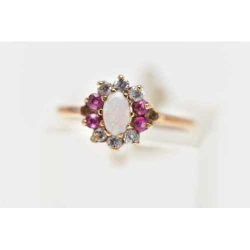 5 - A 9CT YELLOW GOLD CLUSTER RING, centering on an oval opal cabochon, in a surround of six colourless ... 