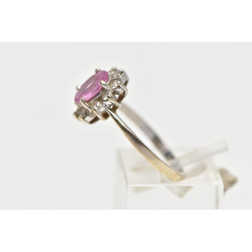 74 - AN 18CT WHITE GOLD PINK SAPPHIRE AND DIAMOND CLUSTER RING, centering on a four claw set, oval cut pi... 