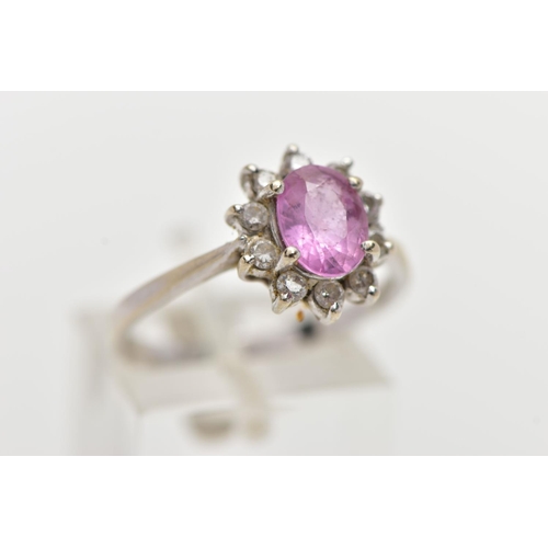 74 - AN 18CT WHITE GOLD PINK SAPPHIRE AND DIAMOND CLUSTER RING, centering on a four claw set, oval cut pi... 