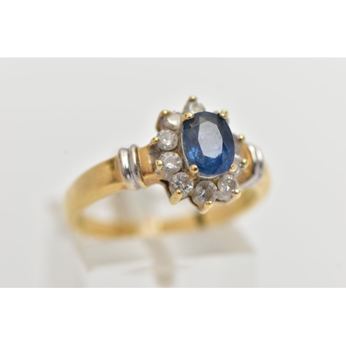 76 - AN 18CT GOLD SAPPIRE AND DIAMOND CLUSTER RING, centering on a raised oval cut blue sapphire, within ... 