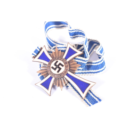 235 - TWO WW2 BRONZE MOTHERS CROSSES AND A SEW ON BADGE, the bronze mothers cross was given to mothers who... 