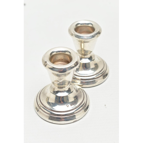 129 - A PAIR OF SILVER CANDLESTICKS, dwarf candlesticks, tapering in form to the round stepped, weighted b... 