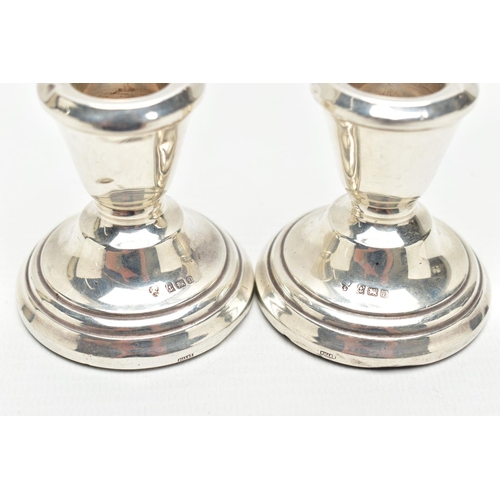 129 - A PAIR OF SILVER CANDLESTICKS, dwarf candlesticks, tapering in form to the round stepped, weighted b... 