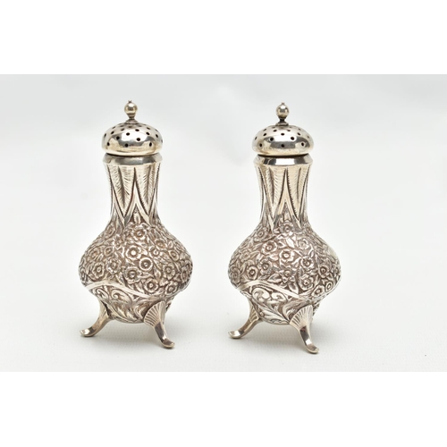 130 - A PAIR OF WHITE METAL PEPPERETTES, baluster form, decorated with a floral and foliate pattern, engra... 