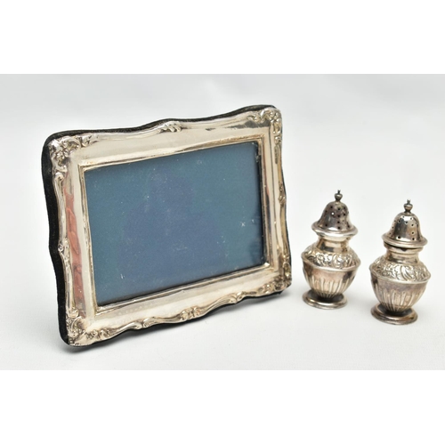 136 - A PAIR OF SILVER PEPPERETES AND A SILVER PHOTO FRAME, a pair of bluster form pepperettes, embossed w... 