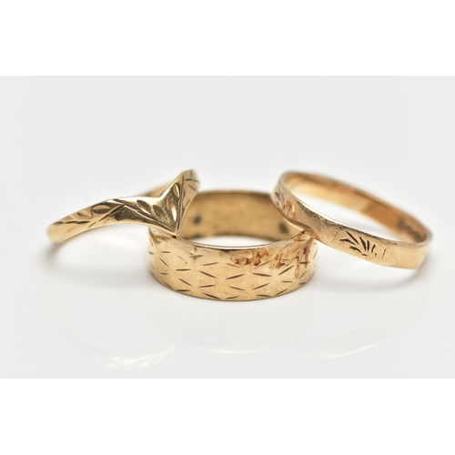 28 - THREE 9CT YELLOW GOLD RINGS, to include a wide band with engraved detail, a wish bone ring and a fac... 