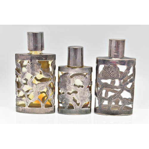 44 - THREE MEXICAN SCENT BOTTLES, the glass bottles with pierced foliate designed cases, all stamped ster... 