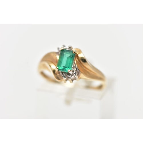 74 - A YELLOW METAL GEM SET RING, designed with a four claw set, rectangular cut emerald, between single ... 