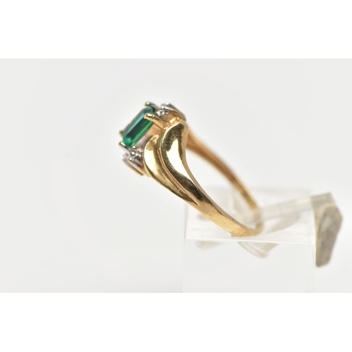 74 - A YELLOW METAL GEM SET RING, designed with a four claw set, rectangular cut emerald, between single ... 