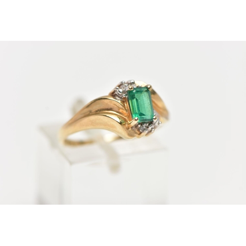 74 - A YELLOW METAL GEM SET RING, designed with a four claw set, rectangular cut emerald, between single ... 