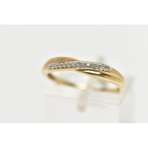 75 - A 9CT YELLOW GOLD DIAMOND HALF ETERNITY RING, cross over style set with a row of single cut diamonds... 