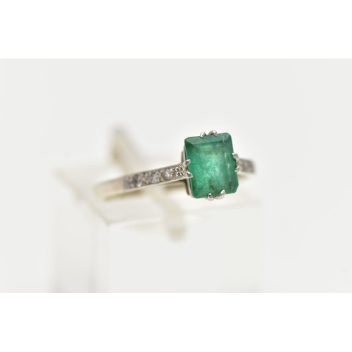 83 - A EMERALD RING, single emerald cut stones, split prong set in white metal flanked with six single cu... 