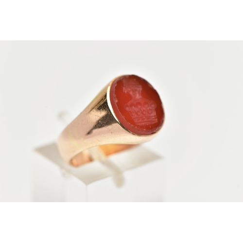 95 - A YELLOW METAL SIGNET RING, an oval carnelian intaglio set within a heavy yellow metal ring, unmarke... 