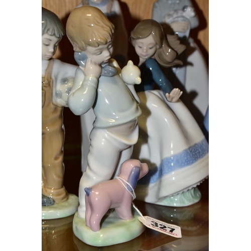 327 - A GROUP OF ELEVEN NAO FIGURINES OF CHILDREN, to include a girl with puppy, a boy holding a telephone... 