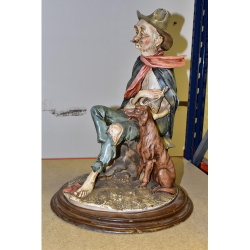 385 - A LARGE CAPODIMONTE FIGURE, featuring a seated old man with his dog and a bottle of wine, height 45c... 