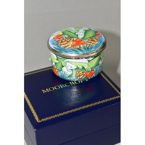 364 - A BOXED MOORCROFT ENAMELS TRINKET BOX, of cylindrical form, decorated with sprigs of fir, fir cones,... 