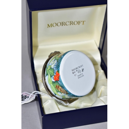 364 - A BOXED MOORCROFT ENAMELS TRINKET BOX, of cylindrical form, decorated with sprigs of fir, fir cones,... 