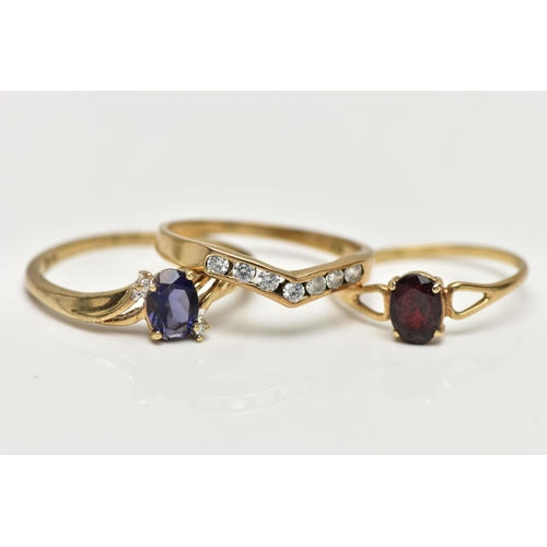 8 - THREE 9CT GOLD GEM SET RINGS, the first designed with a four claw set, oval cut tanzanite, flanked w... 