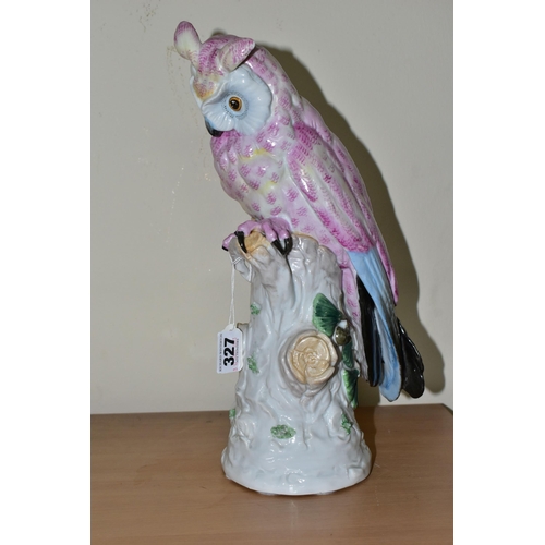 327 - A 20TH CENTURY CONTINENTAL PORCELAIN OWL, decorated in pink and blue, perched on a white tree stump,... 