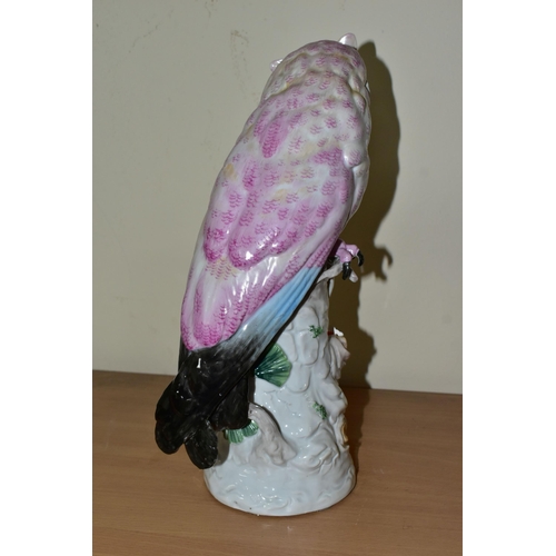 327 - A 20TH CENTURY CONTINENTAL PORCELAIN OWL, decorated in pink and blue, perched on a white tree stump,... 