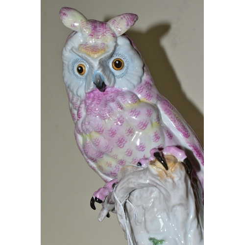 327 - A 20TH CENTURY CONTINENTAL PORCELAIN OWL, decorated in pink and blue, perched on a white tree stump,... 