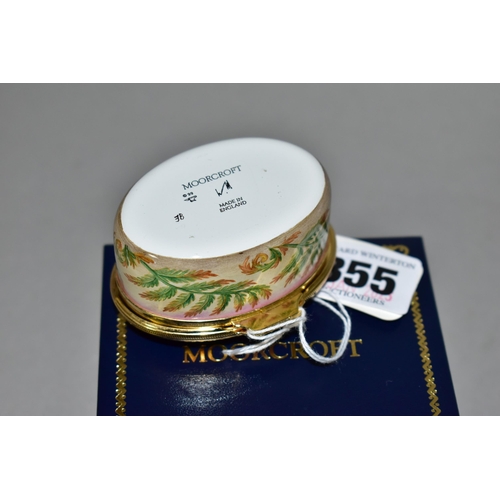 355 - A BOXED MOORCROFT ENAMEL TRINKET BOX, of oval form, decorated in the 'Foxgloves' pattern, with fern ... 