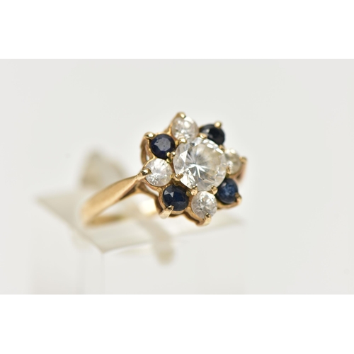 76 - A 9CT YELLOW GOLD CUBIC ZIRCONIA AND SAPPHIRE CLUSTER RING, the principal colourless cubic zirconia ... 