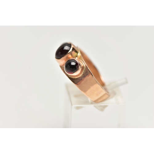 80 - A GARNET THREE STONE RING, set with a principal oval garnet cabochon, and two circular garnet caboch... 