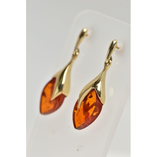 17 - A PAIR OF 9CT GOLD, AMBER DROP EARRINGS, each designed as an oval amber drop in a yellow gold mount,... 