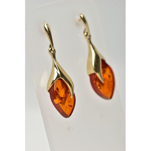 17 - A PAIR OF 9CT GOLD, AMBER DROP EARRINGS, each designed as an oval amber drop in a yellow gold mount,... 