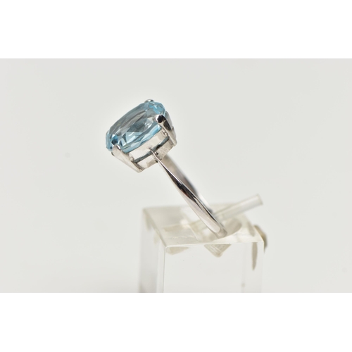 2 - A MODERN 18CT GOLD TOPAZ RING, an oval cut light blue topaz, approximate dimensions length 12mm x wi... 