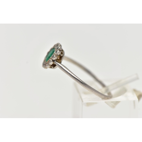 54 - A WHITE METAL, EMERALD AND DIAMOND CLUSTER RING, centering on an emerald cut emerald, in a milgrain ... 