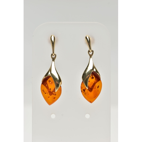 17 - A PAIR OF 9CT GOLD, AMBER DROP EARRINGS, each designed as an oval amber drop in a yellow gold mount,... 