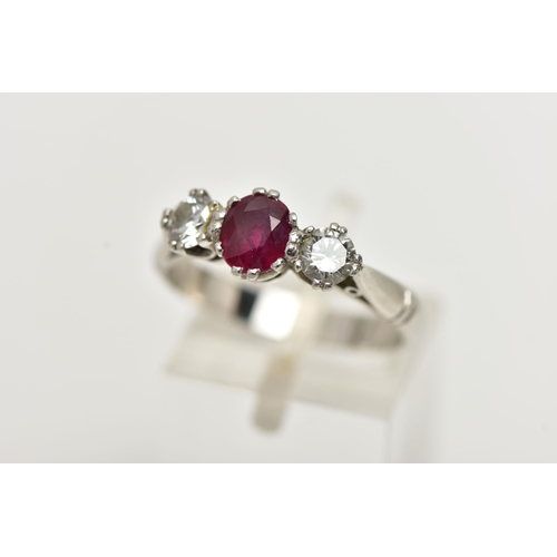 36 - A PLATINUM RUBY AND DIAMOND THREE STONE RING, centering on an oval cut ruby, flanked with two round ... 