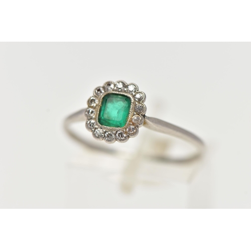 54 - A WHITE METAL, EMERALD AND DIAMOND CLUSTER RING, centering on an emerald cut emerald, in a milgrain ... 