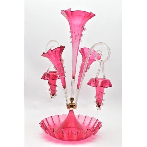 114 - A VICTORIAN CRANBERRY AND CLEAR GLASS EPERGNE, the central trumpet with trailing decoration, enclose... 