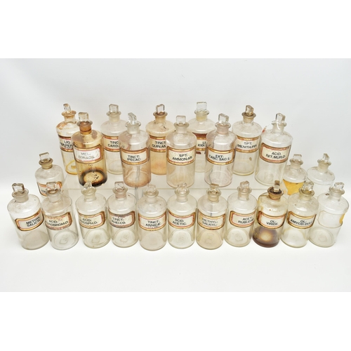 121 - A COLLECTION OF TWENTY FOUR CLEAR GLASS PHARMACY BOTTLES OF CYLINDRICAL FORM WITH STOPPERS, three ar... 