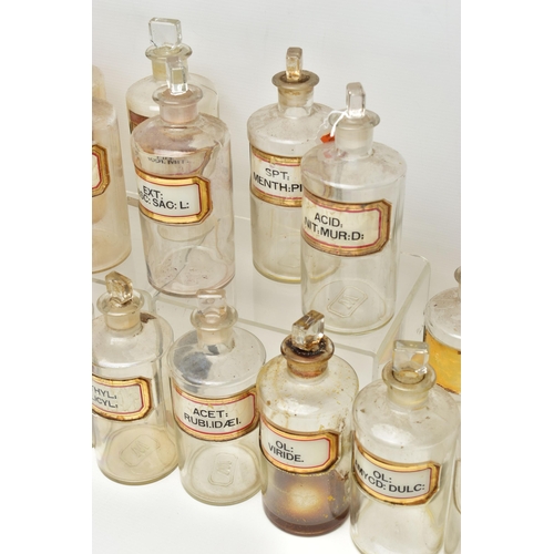 121 - A COLLECTION OF TWENTY FOUR CLEAR GLASS PHARMACY BOTTLES OF CYLINDRICAL FORM WITH STOPPERS, three ar... 