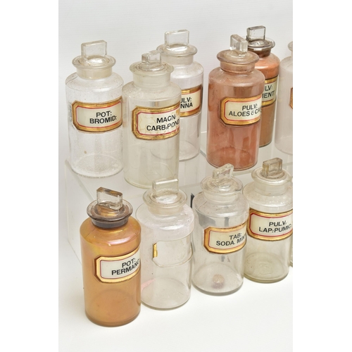 122 - A COLLECTION OF TWENTY CLEAR GLASS PHARMACY BOTTLES OF CYLINDRICAL FORM WITH STOPPERS, one is of a d... 