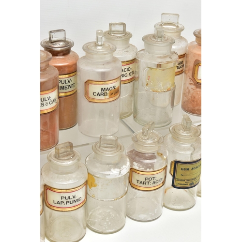 122 - A COLLECTION OF TWENTY CLEAR GLASS PHARMACY BOTTLES OF CYLINDRICAL FORM WITH STOPPERS, one is of a d... 