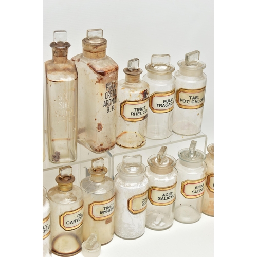 123 - A COLLECTION OF TWENTY ONE CLEAR GLASS PHARMACY BOTTLES WITH STOPPERS, three of rectangular form, ap... 