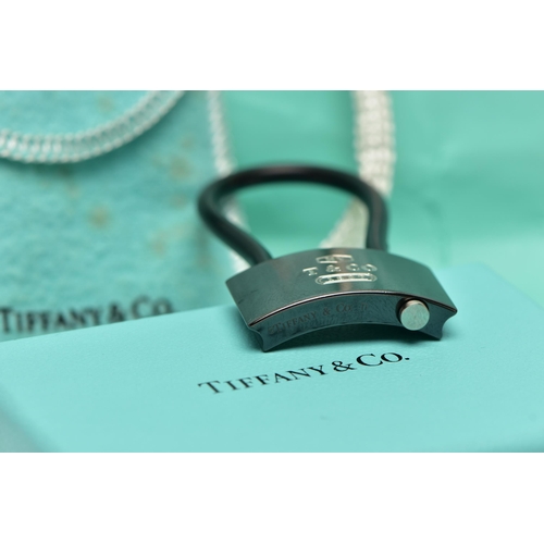 10 - A CASED TIFFANY & CO. PADLOCK, the black titanium padlock, with black rubber loop, signed 'NY T& Co.... 