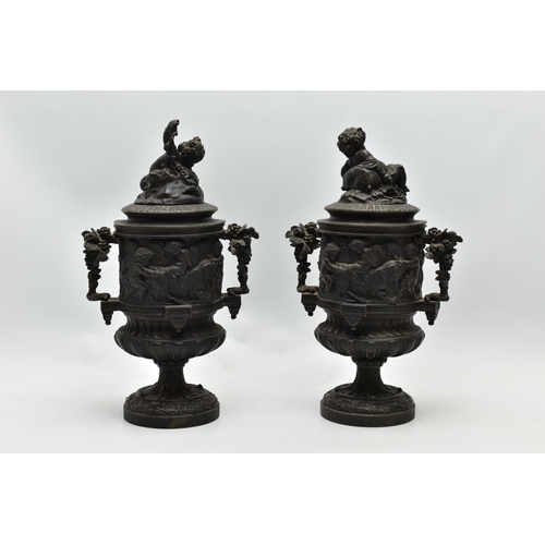 181 - A PAIR OF 19TH CENTURY BLACK PAINTED SPELTER TWIN HANDLED URNS AND COVERS, the covers cast with a pu... 