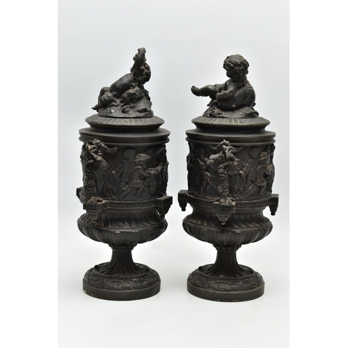 181 - A PAIR OF 19TH CENTURY BLACK PAINTED SPELTER TWIN HANDLED URNS AND COVERS, the covers cast with a pu... 